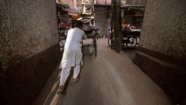 印度男子推车沿着小巷