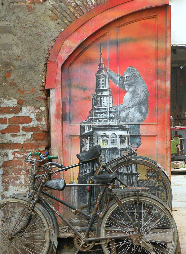 靠在铁门上的破旧自行车图片