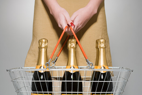 提着购物篮有三瓶香槟的女士图片