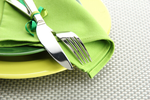 绿色桌布上的刀叉图片
