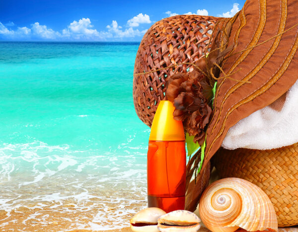 沙滩上的海螺与帽子图片