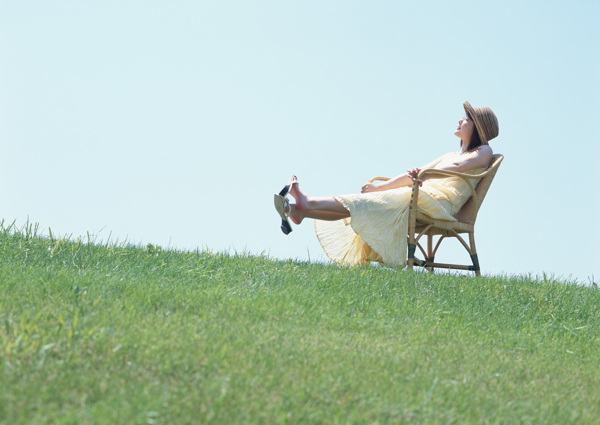 坐在草地上的休闲椅上的美女图片