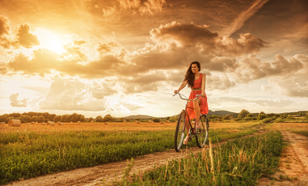 草地上骑单车的女人图片
