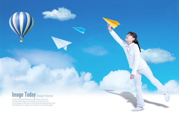 白云上放飞飞机的女孩和热气球