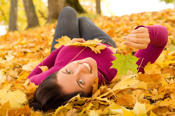 躺在枫叶上的开心美女图片