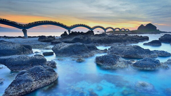 大海天空夕阳大桥礁石
