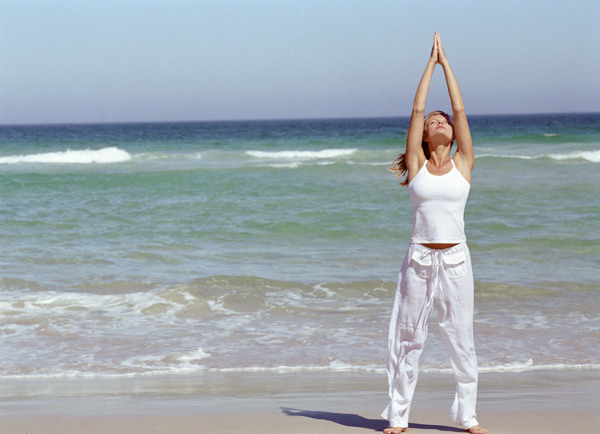 海边练瑜珈的女性图片
