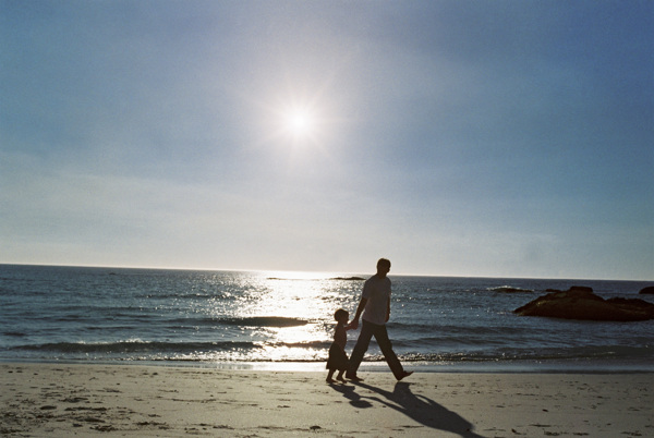 沙滩上散步的父子图片