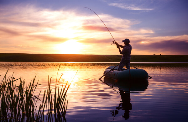 夕阳下钓鱼的男人图片