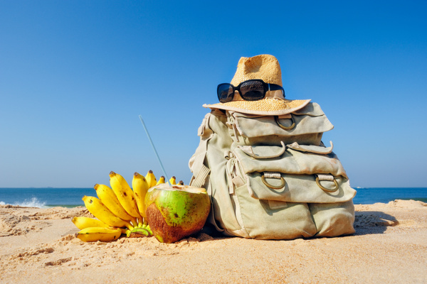 沙滩上的背包与水果