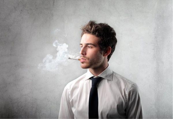 站在墙壁前吸烟的外国男人图片