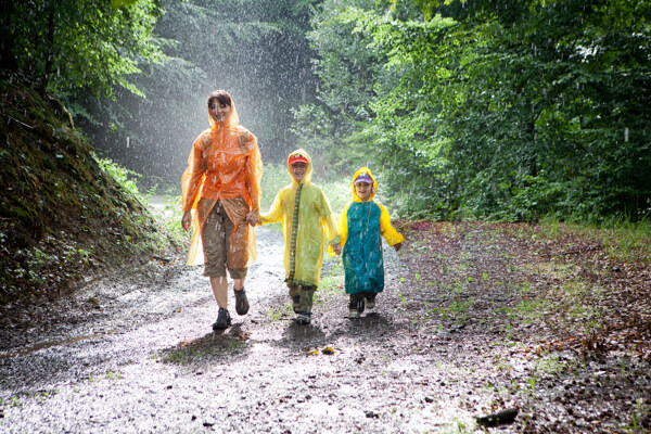 穿着雨衣走在路上的一家人图片