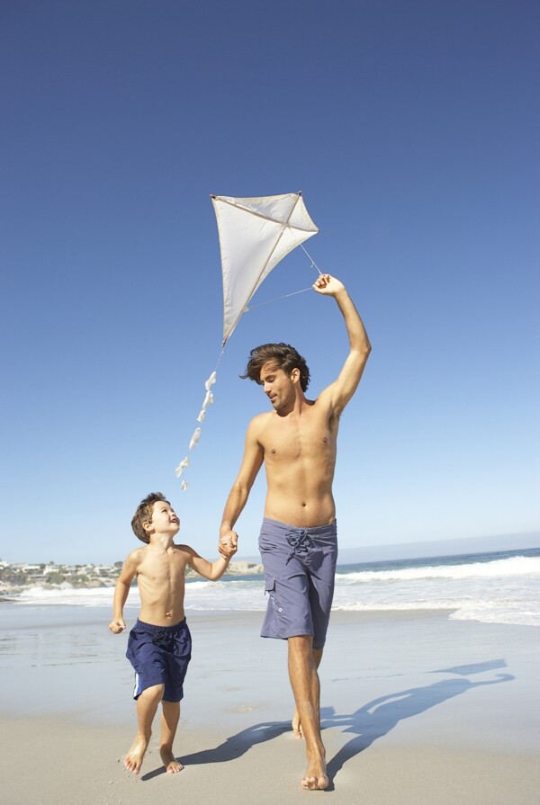 沙滩上放风筝的父子图片