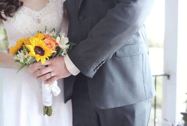 一对新婚夫妻手捧向日葵花束
